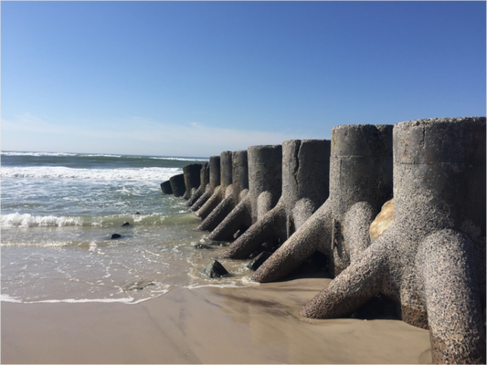 Concrete shoreline protection structures extending into the Atlantic Ocean at Ocean Beach on Fire Island, New York.
